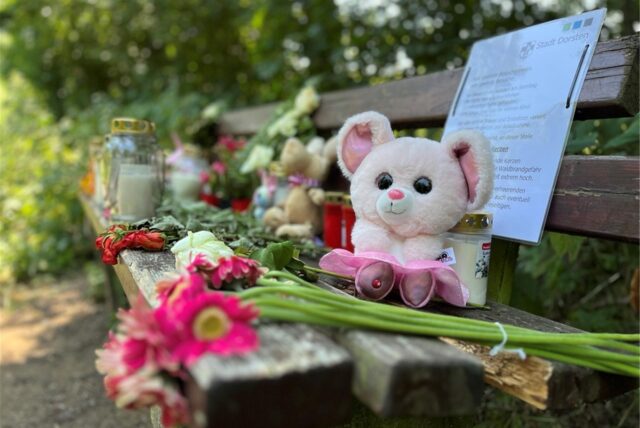 Blumen, Kerzen und Kuscheltiere sind an der Bank am Tüshausweg in Dorsten zum Zeichen der Trauer geworden.