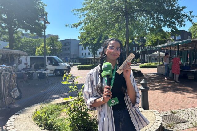 Rosi Taslima Azam hält ein Thermometer hoch.