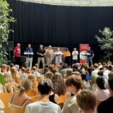 Stefan Springer (von links), Bernhard Felling, Moderator Stefan Prott, Andreas Hebestreit, Babette Nieder, Moderatorin Laura Tirier-Hontoy, Fred Toplak und Patrick Berner stehen im Glashaus Herten auf der Bühne vor einem Publikum.