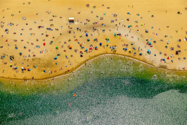 Luftbild vom Strand Silbersee, Sand mit bunten Sonnenschirmen und Decken