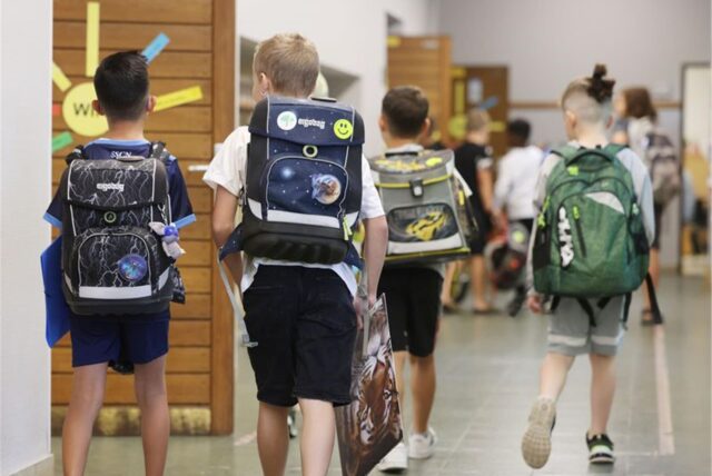 Schüler kommen am Morgen in einer Grundschule zum Unterricht.