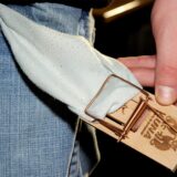 Mausefalle und Geld an einer Hosentasche