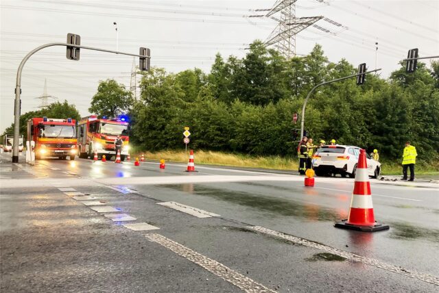 Zwei Einsatzwagen der Feuerwehr Marl stehen auf der B225 in Höhe der A52-Auffahrt. Inmitten der Kreuzung steht ein Pkw, um den einige Rettungskräfte stehen.