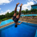 Ein junger Mann springt vom Sprungturm im Freibad Mollbeck in Recklinghausen