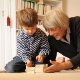 Frau spielt mit einem Kind auf dem Boden