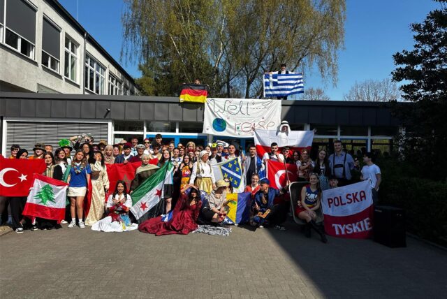 Abiturjahrgang 2025 des Ernst-Barlach-Gymnasiums in Kostümen beim Kulturtag der Mottowoche vor dem Schulgebäude in Castrop-Rauxel.