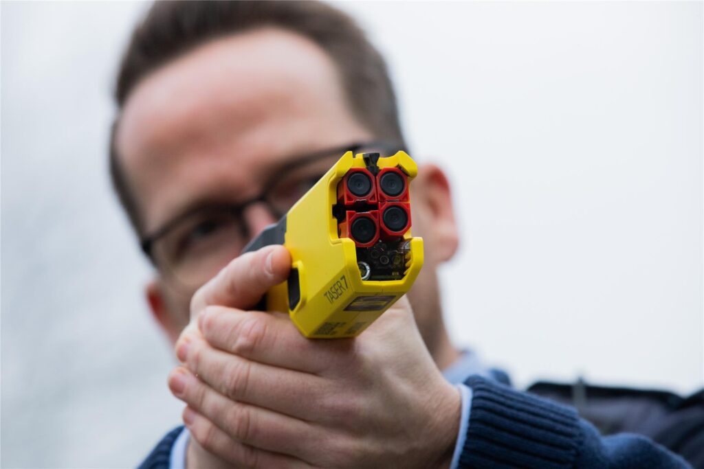 Ein Polizist hält einen Taser Ein Polizist hält einen Taser