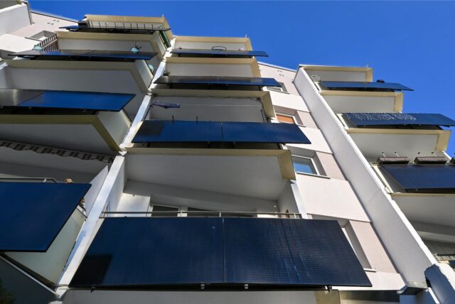 Solarmodule an den Balkonen eines Mehrfamilienhauses