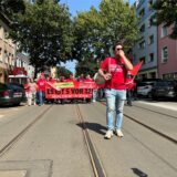 Bereits im Sommer 2024 hatte die Belegschaft von Thyssenkrupp in Dortmund gegen den drohenden Stellenabbau protestiert. Moritz Engels, Betriebsratschef, steht hier vor der Demo und spricht durch ein Megafon.