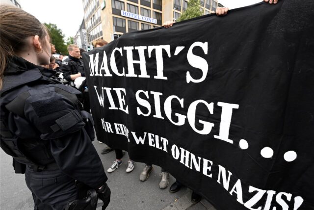 Gegendemonstranten halten ein Banner mit der Aufschrift „Macht’s wie Siggi“ anlässlich des rechten Aufmarschs in ihrer Stadt hoch.