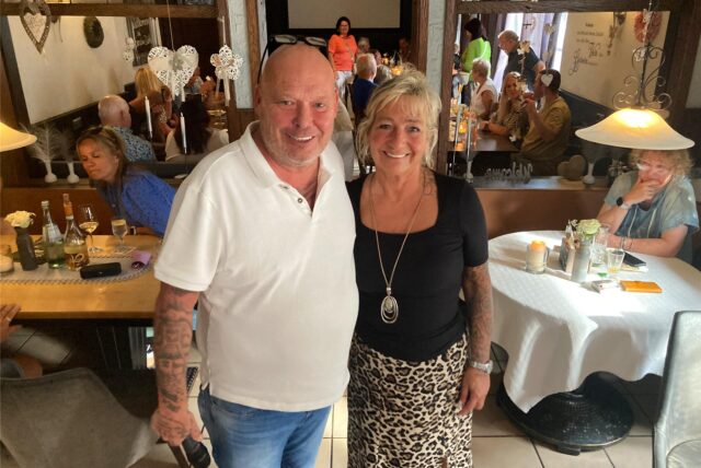Dirk und Sandra Lasarz stehen im Kaiserhof Herten inmitten der Restaurant-Gäste.