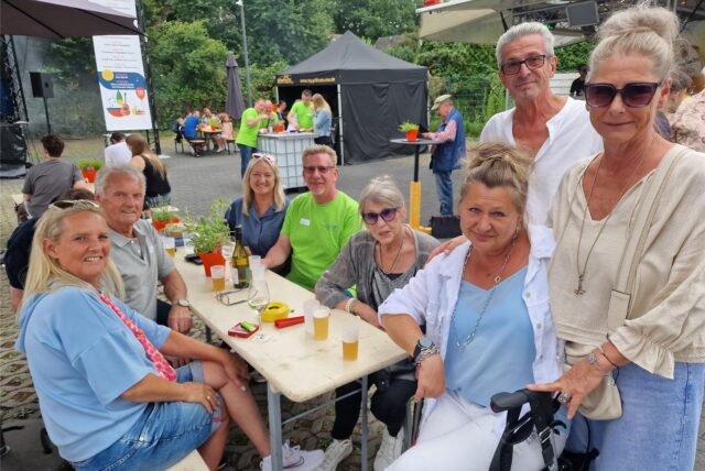 Besucherinnen und Besucher des Tages der offenen Tür bei den Hertener Stadtwerken sitzen auf dem Betriebsgelände in Herten-Süd um einen Tisch herum.