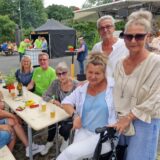 Besucherinnen und Besucher des Tages der offenen Tür bei den Hertener Stadtwerken sitzen auf dem Betriebsgelände in Herten-Süd um einen Tisch herum.