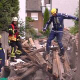 Einsatzkräfte des THW auf einem Berg Bauschutt an der Provinzialstraße in Bövinghausen.
