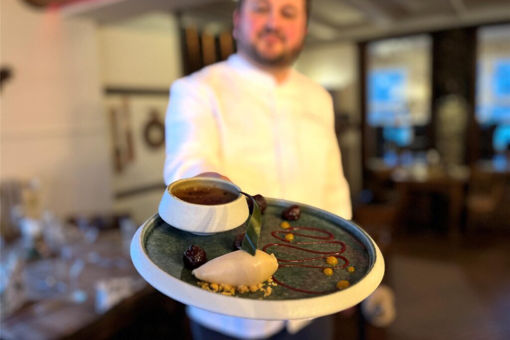 Der Küchenchef Suvad Memovic hält eine der Dessertspeisen des Haus Hölster in die Kamera. Das Crème brûlée mit Nougat. Der Küchenchef Suvad Memovic hält eine der Dessertspeisen des Haus Hölster in die Kamera. Das Crème brûlée mit Nougat.