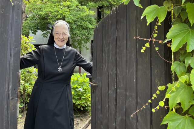 Schwester Aloysiana am Tor zum Pfarrgarten.