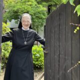 Schwester Aloysiana am Tor zum Pfarrgarten.