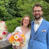 Das Hochzeitspaar Caroline Reddemann und Marius Bilke steht vor der Hochzeitstorte.