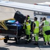 Mitarbeiter eines deutschen Flughafens verladen Koffer in ein Flugzeug.
