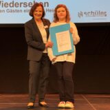 Maria Koschelew steht auf der Bühne bei der Siegerehrung des NRW-Schülerwettbewerbs „Begegnung mit Osteuropa“.