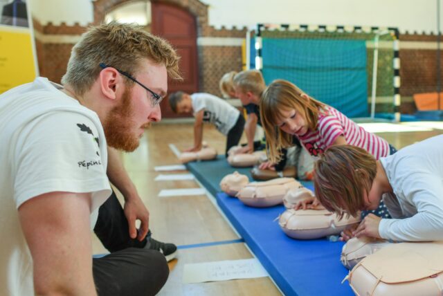 Philipp Humbsch, Student der Humanmedizin an der Charité-Universitätsmedizin Berlin, übt mit Kindern der Friedensgrundschule in Frankfurt (Oder) die Wiederbelebung an einem Dummy.
