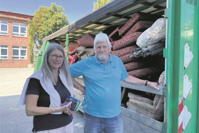 Ruth Dirks und Friedhelm Hauk-Dirks stehen neben einem Container mit Möbeln.