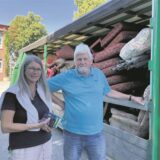 Ruth Dirks und Friedhelm Hauk-Dirks stehen neben einem Container mit Möbeln.