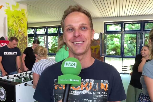 Schulsozialarbeiter Nils Schuchardt steht in der Gesamtschule Waltrop, hinter ihm wird gekickert.