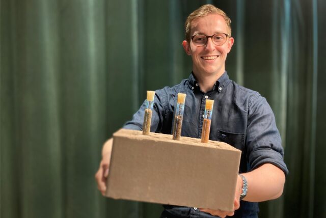 Bauingenieur Florian Soßna mit einem Lehmstein, der sich ideal für Wohngebäude eignet.