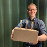 Bauingenieur Florian Soßna mit einem Lehmstein, der sich ideal für Wohngebäude eignet.
