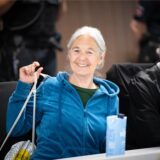 Daniela Klette sitzt lächelnd neben ihrem Anwalt im Gericht