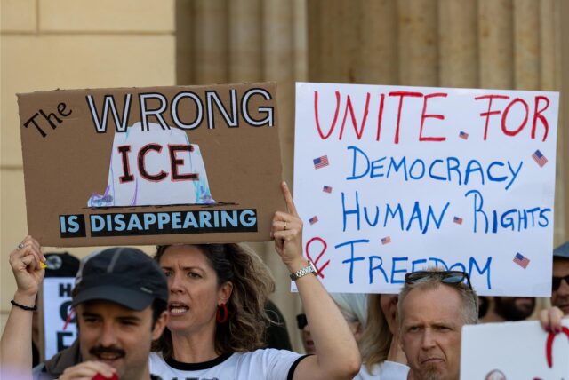 Eine Teilnehmerin einer Demonstration der Democrats Abroad Germany (Demokraten im Ausland) hält nahe der US-Botschaft auf dem Pariser Platz versammelt ein Plakat mit der Aufschrift „Wrong ICE is disappearing“.