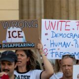 Eine Teilnehmerin einer Demonstration der Democrats Abroad Germany (Demokraten im Ausland) hält nahe der US-Botschaft auf dem Pariser Platz versammelt ein Plakat mit der Aufschrift „Wrong ICE is disappearing“.