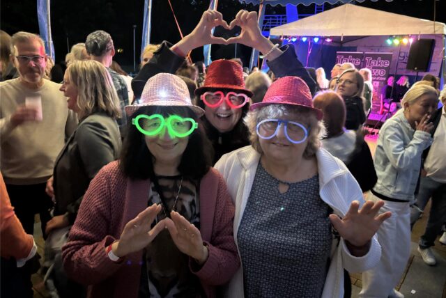 Drei Frauen mit leuchtenden Brillen bei einer Party