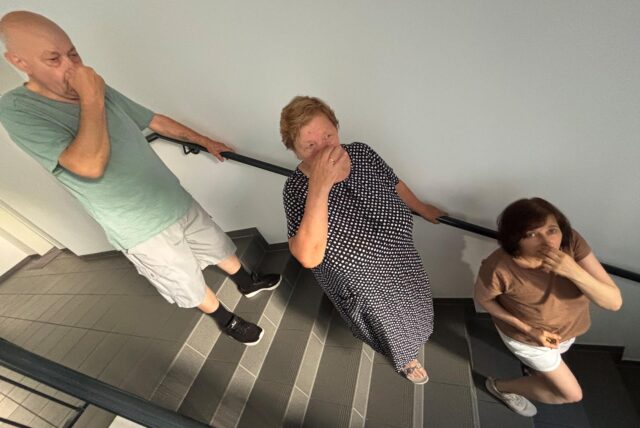 Mieter in Dortmund halten sich auf einer Kellertreppe die Nase zu.