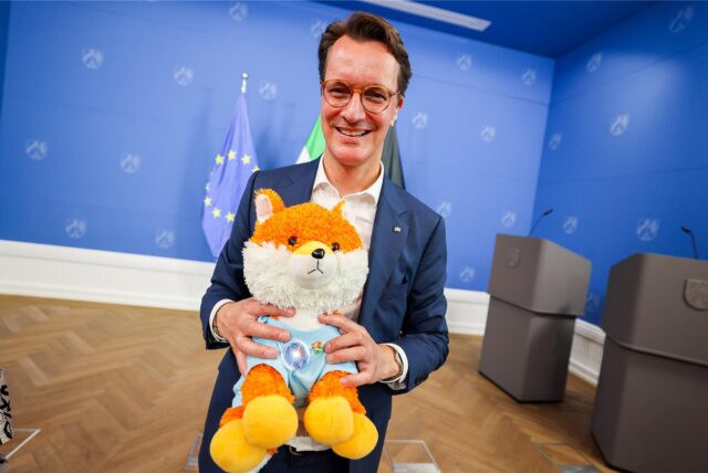 Hendrik Wüst hält Plüsch-Fuchs in der Hand