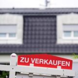 Ein Schild mit der Aufschrift „Zu verkaufen“ vor einem Haus