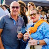 Ein Mann und eine Frau halten Weingläser auf dem Feierabendmarkt in Dortmund.
