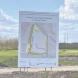 Die Montage zeigt Stadtplanungsdezernentin Jeanette Sebrantke neben dem Bauschild zum Gewerbepark Dicker Dören.