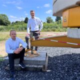 Kevin Rybaczyk und René Fitze, die neu gewählten DRK-Vorstände, an einem Kran.