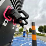 Man sieht zwei Ladepistolen einer Elektroladestation. Die Kabel der Pistolen sind bis oben abgetrennt. Die Kupferenden sind zu erkennen.