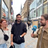 Ein Reporter spricht mit zwei Passanten.