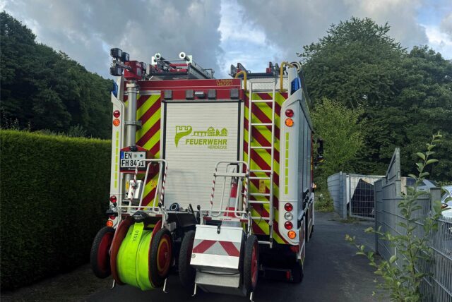 Ein Feuerwehrfahrzeug steht an einem Zaun.