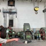 Ein Bergmann zeigt auf eine alte Fördermaschine auf einer Zeche in Marl.