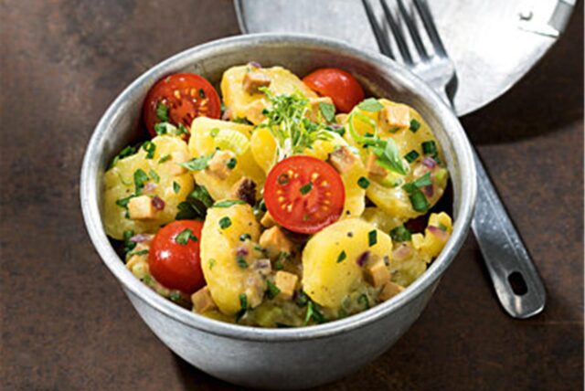 Ein Kartoffelsalat mit Tomaten und Petersilie in einer Schüssel. (Symbolbild)