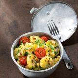 Ein Kartoffelsalat mit Tomaten und Petersilie in einer Schüssel. (Symbolbild)