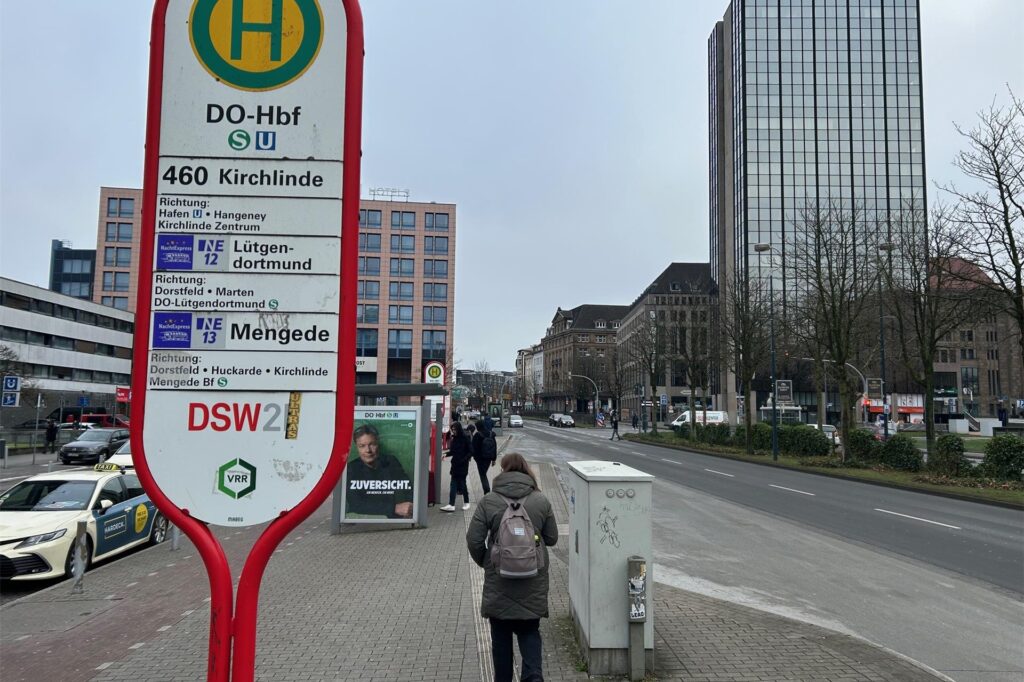 Vor dem Hauptbahnhof Dortmund warten Fahrgäste an einer Bushaltestelle.