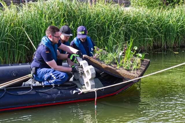 THW-Mitarbeiter lassen Pflanzinseln zu Wasser