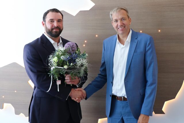 Andreas Schlüter schüttelt Niklas Karwath (l). die Hand. Niklas Karwath hält einen Blumenstrauß.