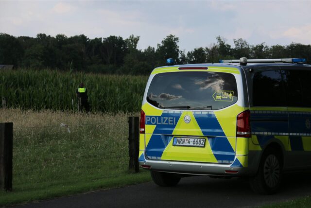 Polizeiauto steht vor einem Maisfeld